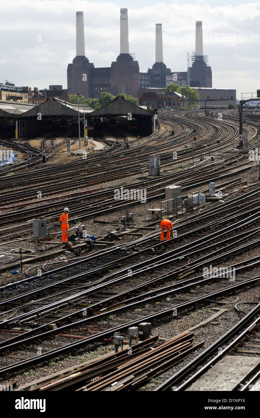 Les ingénieurs qui travaillent sur une ligne de chemin de fer entrant dans la gare de Victoria, Londres. Banque D'Images