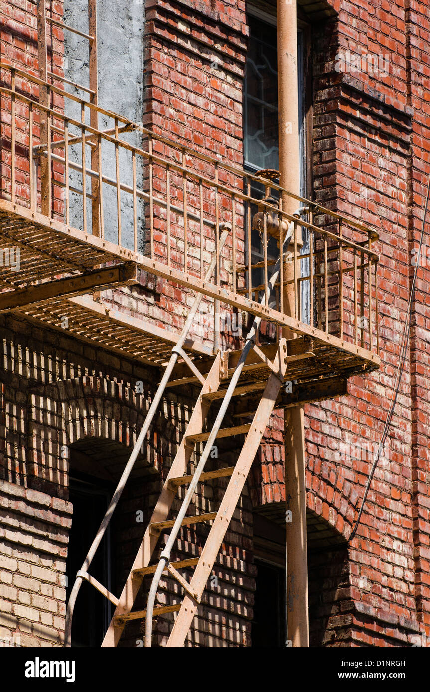 Un escalier de secours sur un vieux bâtiment en briques rouges dans le quartier chinois, San Francisco, Californie Banque D'Images