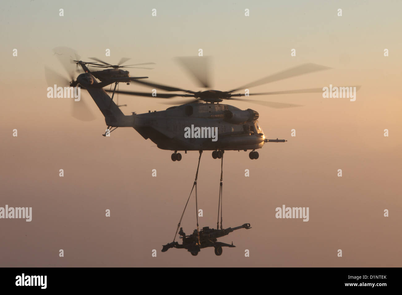 Deux Corps des Marines américains CH-53E Super Etalons avec Marine l'Escadron d'hélicoptères lourds (HMH), 361 aéronefs maritimes Groupe 16, 3rd Marine Aircraft Wing (avant), l'externe ascenseur obusier M777 plus de la province de Helmand, Afghanistan, le 29 décembre 2012. HMH-361 fourni Banque D'Images