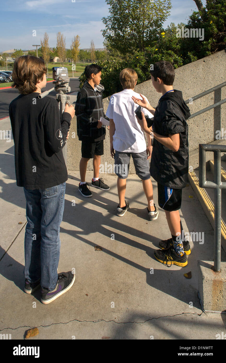 Multi-ethnic preteen garçons travaillent ensemble pour faire une vidéo à leur San Clemente, CA, l'école intermédiaire. Banque D'Images