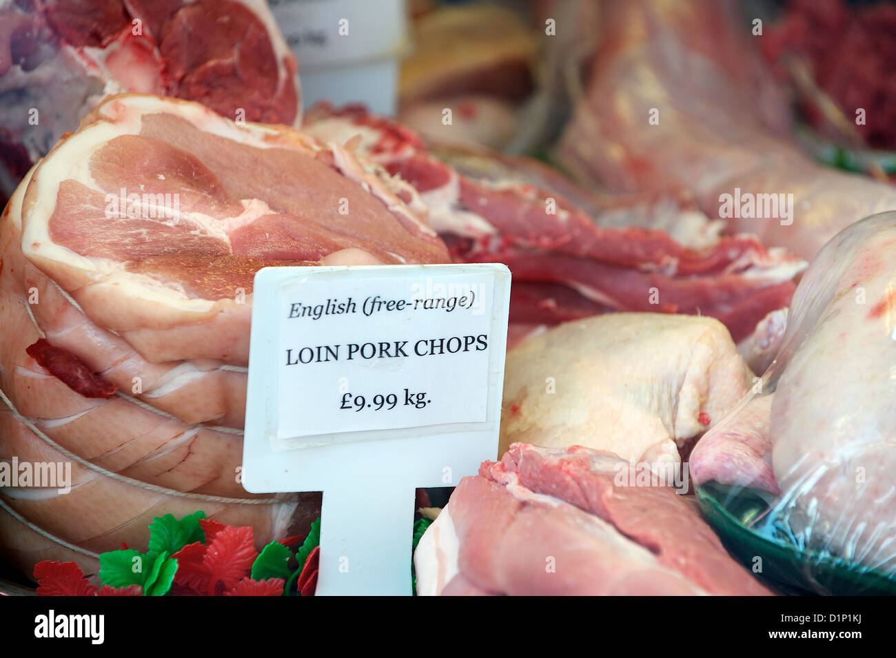 English free range longe de porc et le prix à la vente dans une boucherie vitrine, London, England, UK Banque D'Images