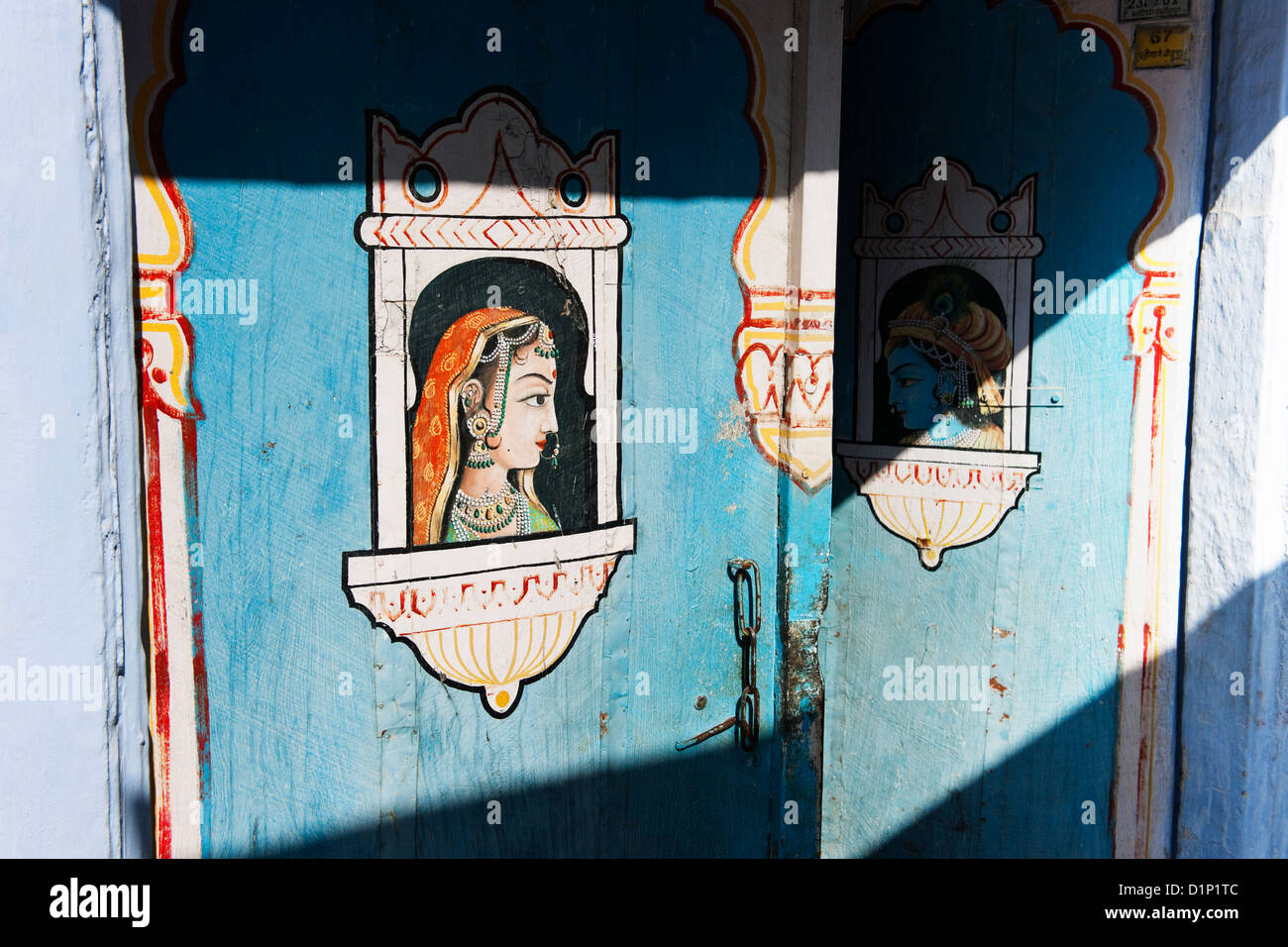 Une porte de couleur au soleil décorées en bleu avec Indian male et femelle montré comme divinité à Windows de l'un vers l'autre Banque D'Images