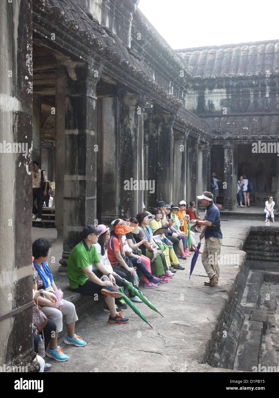 Hommes Femmes asiatique assis à l'intérieur à Angkor Wat Banque D'Images