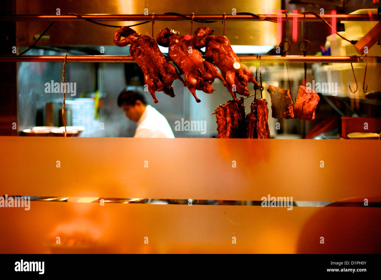 La cuisine de l'homme dans un restaurant chinois avec des canards à la  broche dans la fenêtre, Paris, France Photo Stock - Alamy