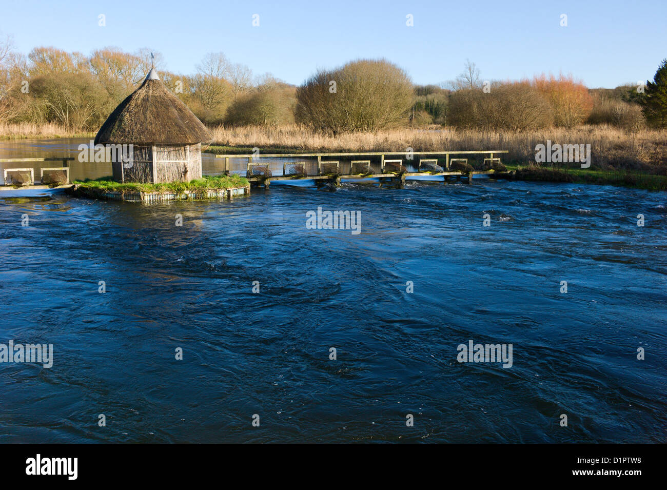 Test de la rivière, Longstock, Hampshire, England, UK - toit de chaume fishermans hut et les pièges de l'anguille Banque D'Images