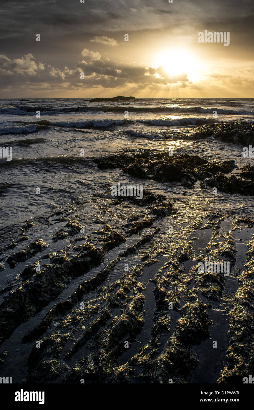 Spectaculaire coucher de soleil d'hiver sur la mer depuis une plage rocheuse. Ayrmer Cove, Ringmore, South Devon, Royaume-Uni Banque D'Images