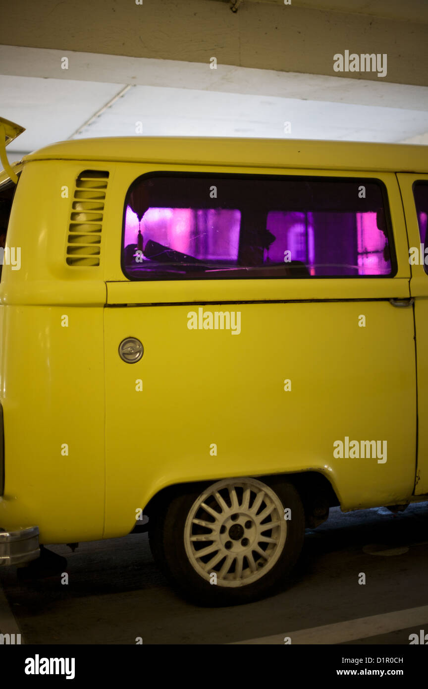 Extrémité arrière d'un campervan VW jaune avec des fenêtres teintées de pourpre Banque D'Images