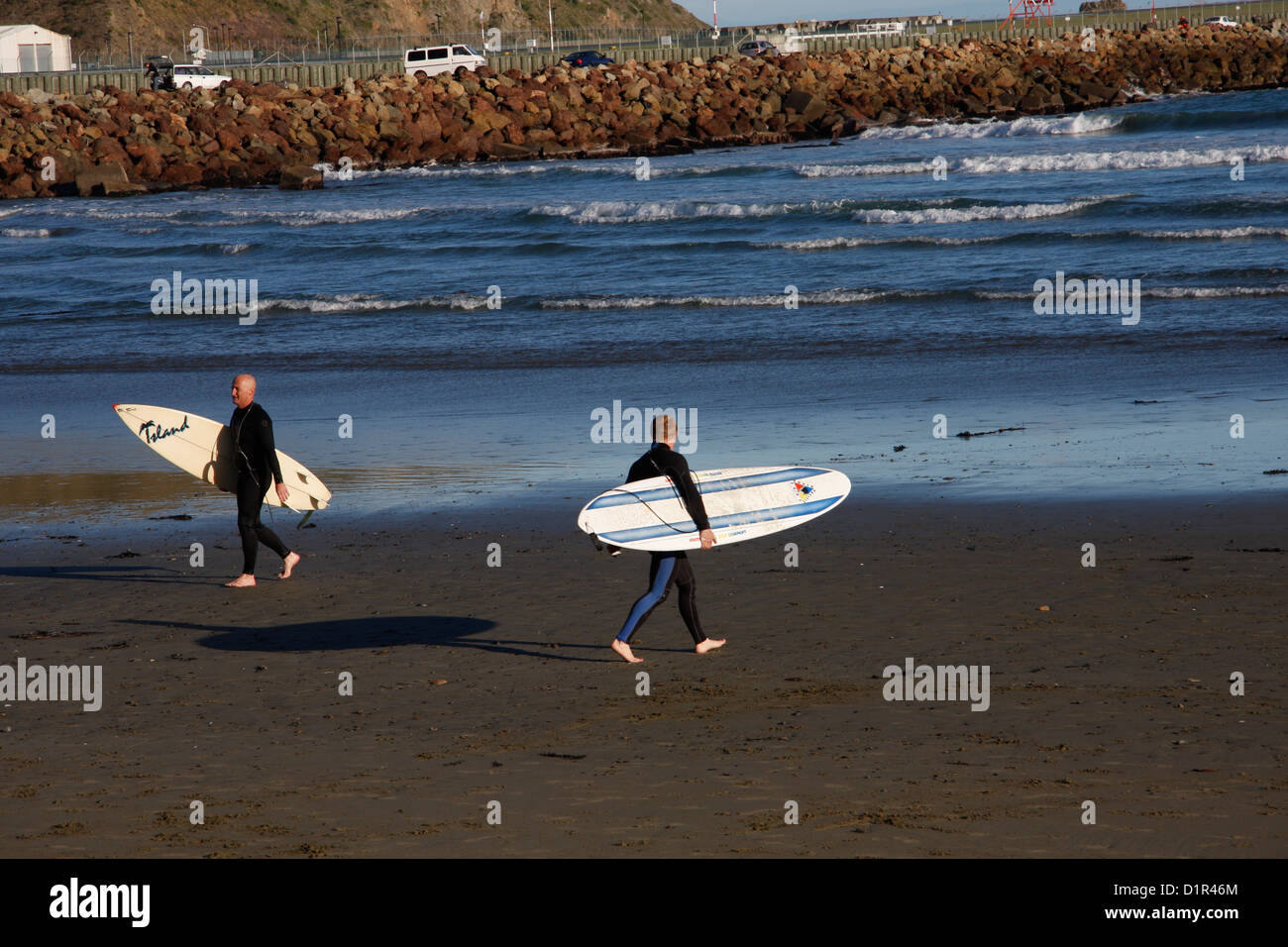 Les surfeurs sur la plage de la baie Lyall, Wellington. Banque D'Images