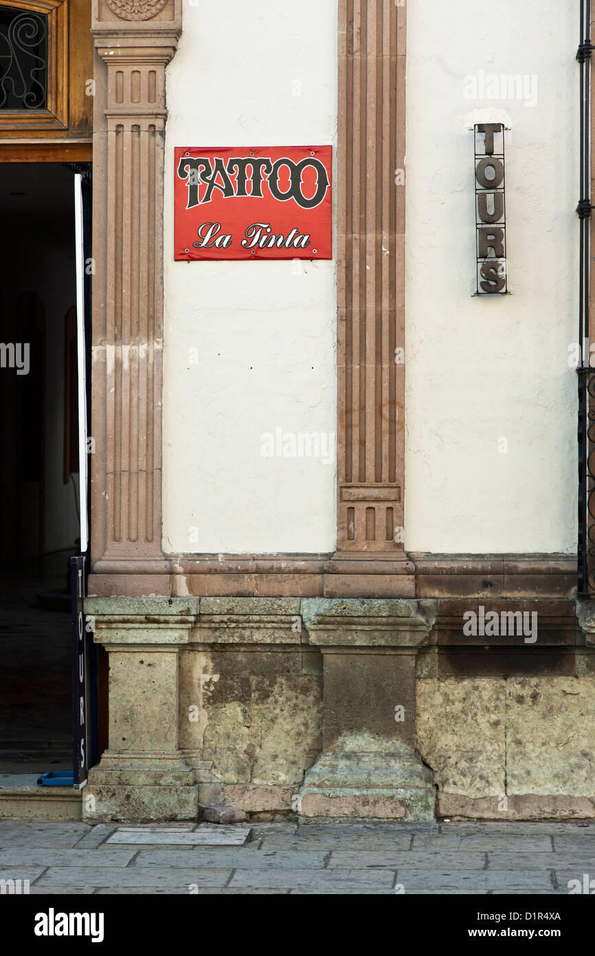 Publicité enseignes tours et un salon de tatouage sur la façade de l'édifice colonial espagnol sur la Calle Alcala Oaxaca Mexique Macedonio Banque D'Images