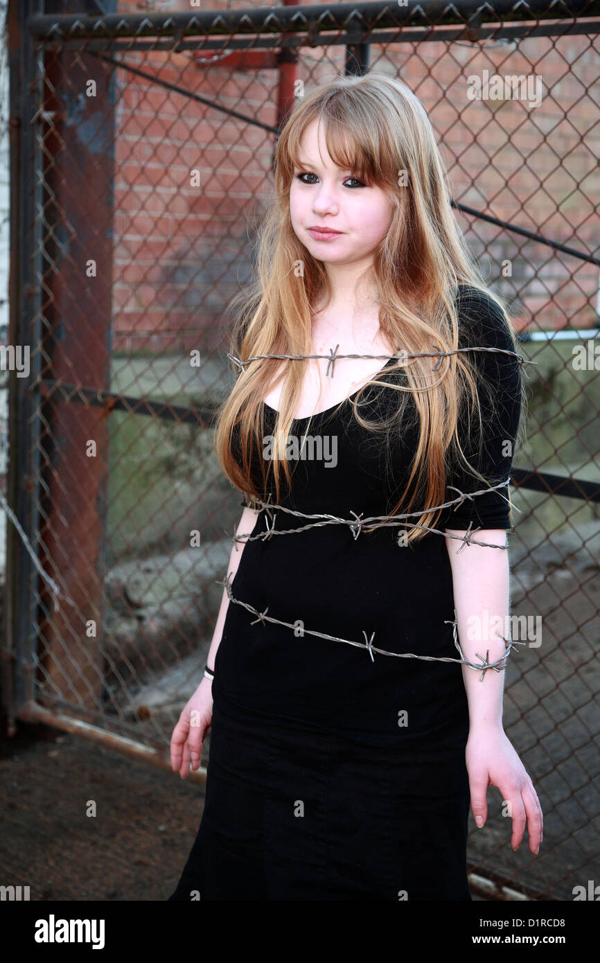 Teenage girl blonde attachées avec du fil de fer barbelé, fausse bande lors d'une séance photo. Février 2008 Banque D'Images