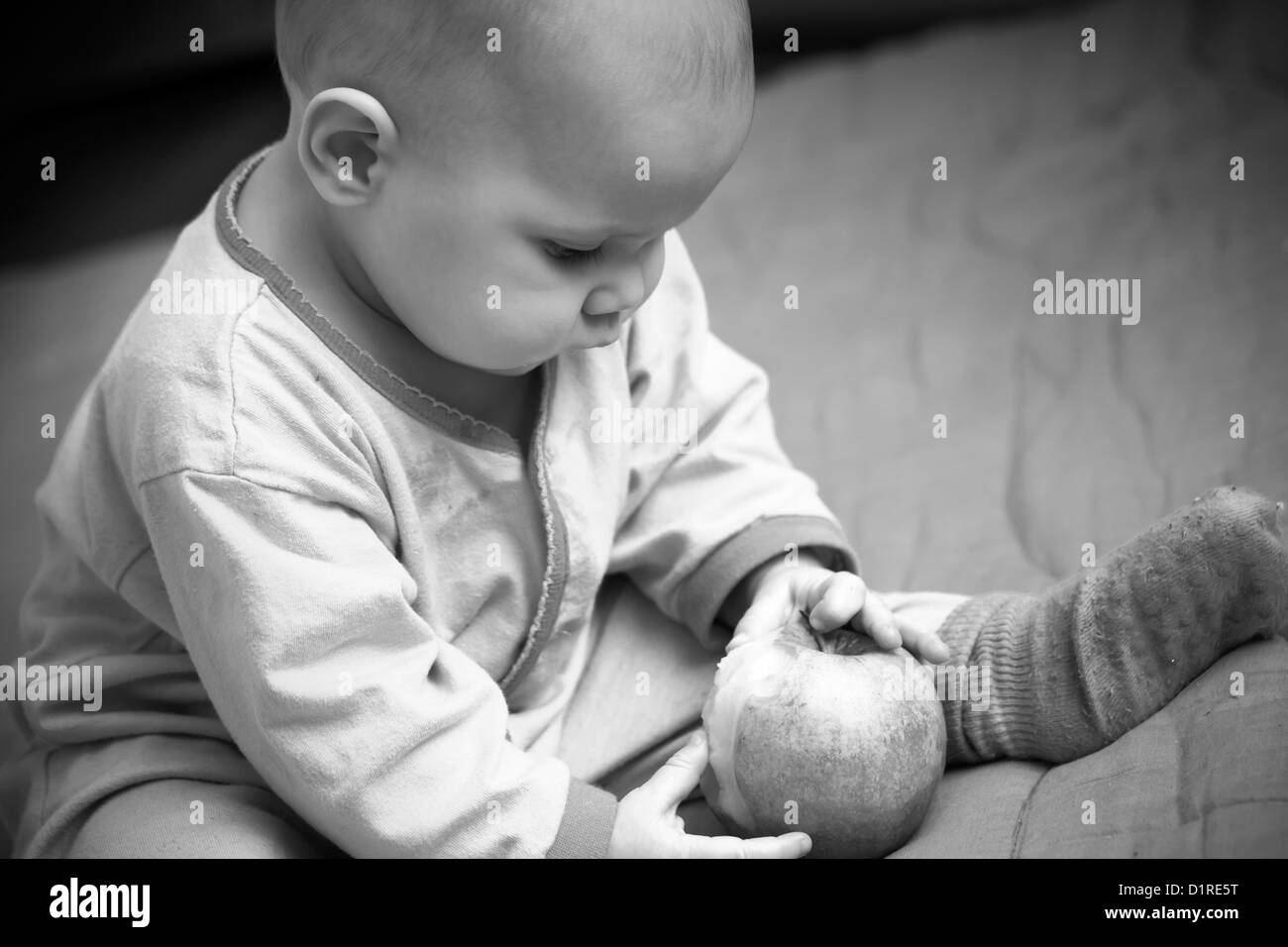 Un petit bébé et une pomme, monochrome photo naturelle Banque D'Images