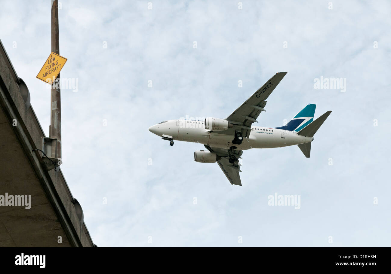 Un avion Boeing 737 de Westjet volant bas sur le pont Arthur Laing juste avant l'atterrissage à l'Aéroport International de Vancouver Banque D'Images