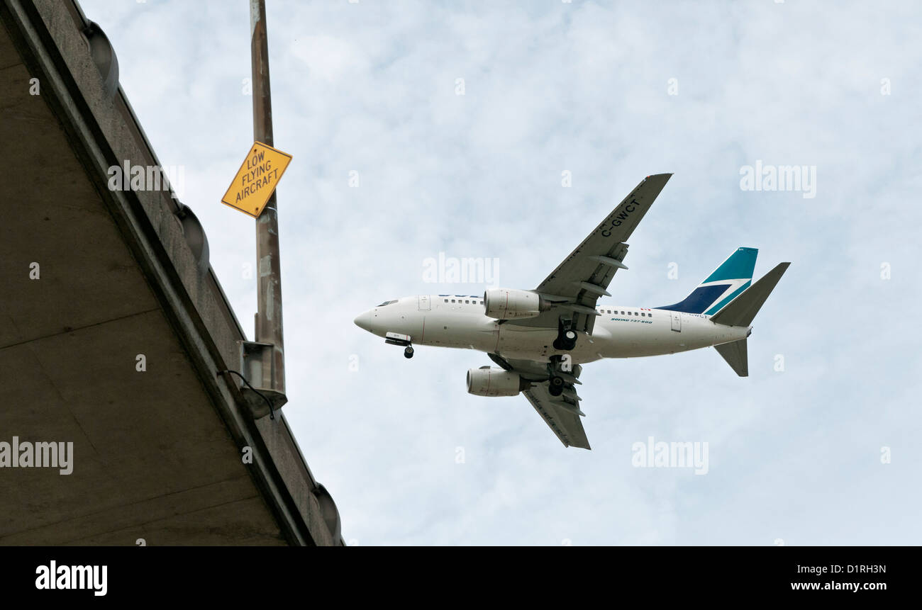 Un avion Boeing 737 de Westjet volant bas sur le pont Arthur Laing juste avant l'atterrissage à l'Aéroport International de Vancouver Banque D'Images