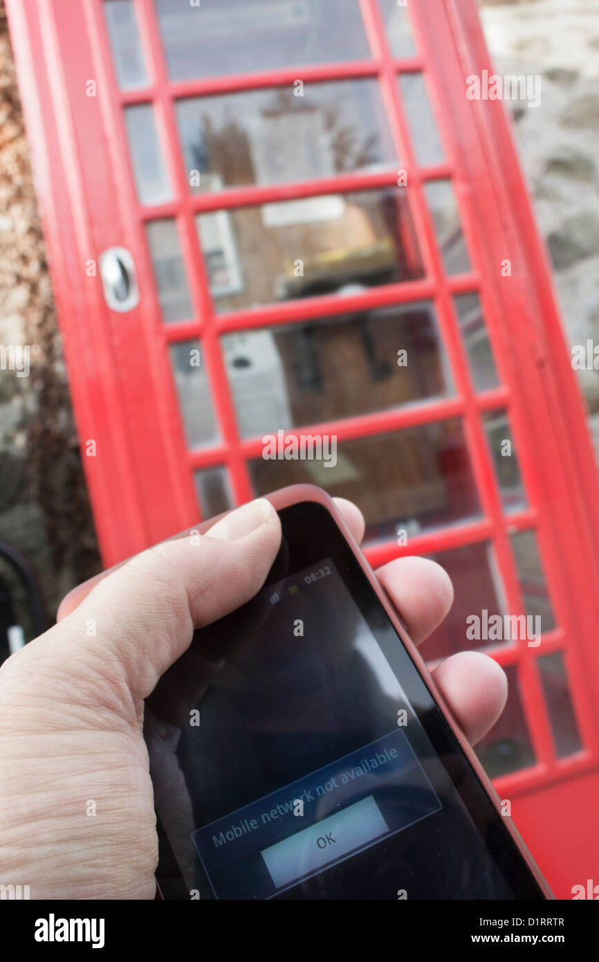 Man holding mobile phone ; réseau mobile non disponible, téléphone rouge fort en arrière-plan Banque D'Images