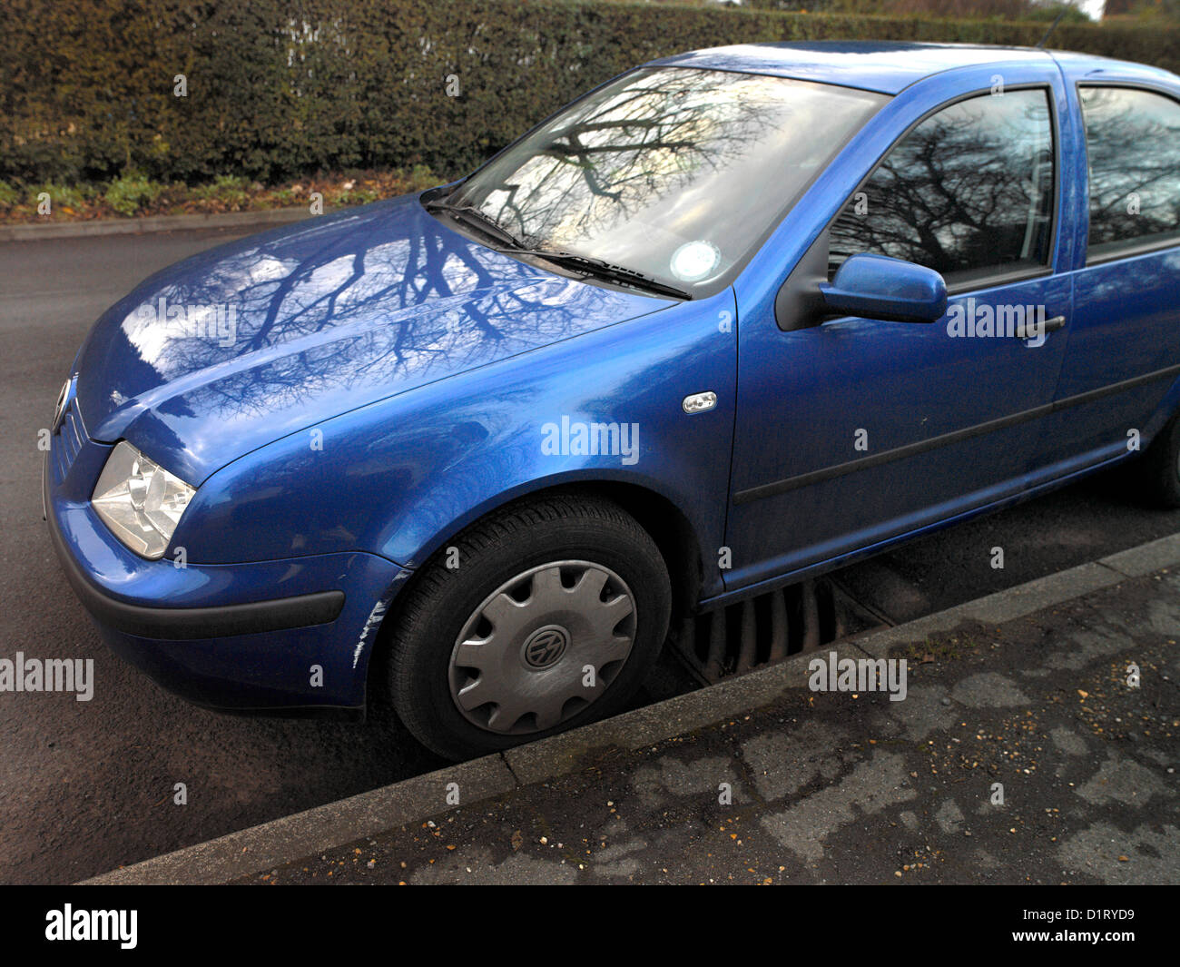 VW Bora bleu endommagé avec passage de roue sur la peinture blanche Banque D'Images