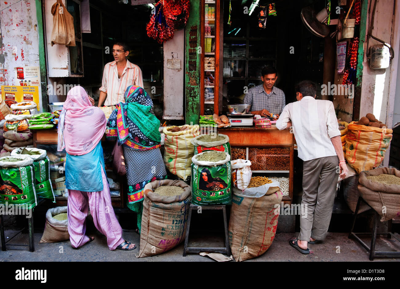 Les commerçants indiens vente de produits d'épicerie dans un décor coloré aux clients indiens à Udaipur Rajasthan Inde Banque D'Images