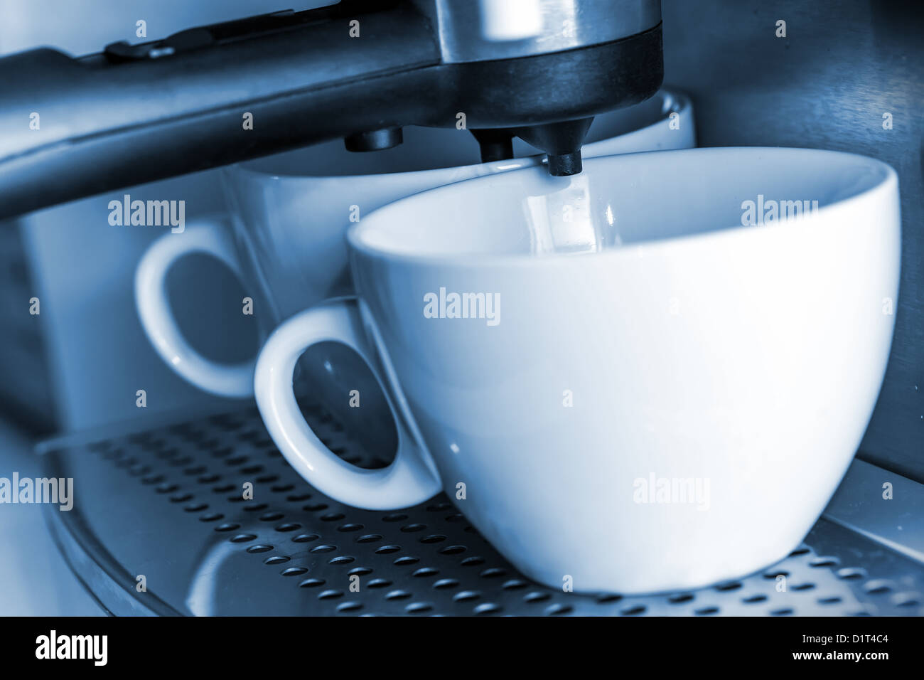 Tasses en céramique blanche vide dans une machine à expresso. Banque D'Images