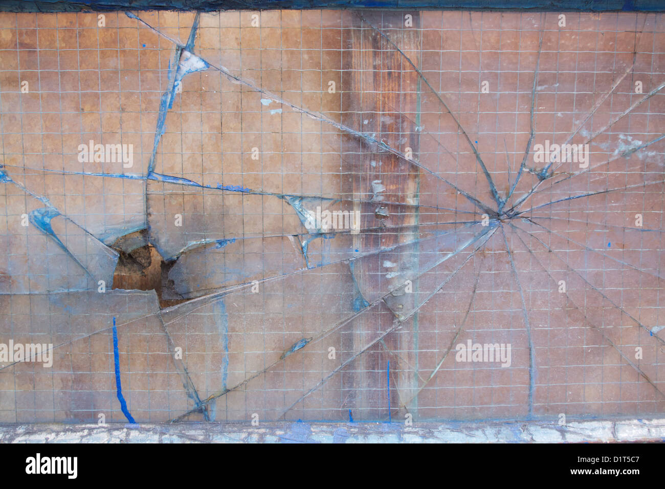 Verre de sécurité cassé avec des fissures qui rayonnent vers l'extérieur dans un trou et formation web spiders Banque D'Images