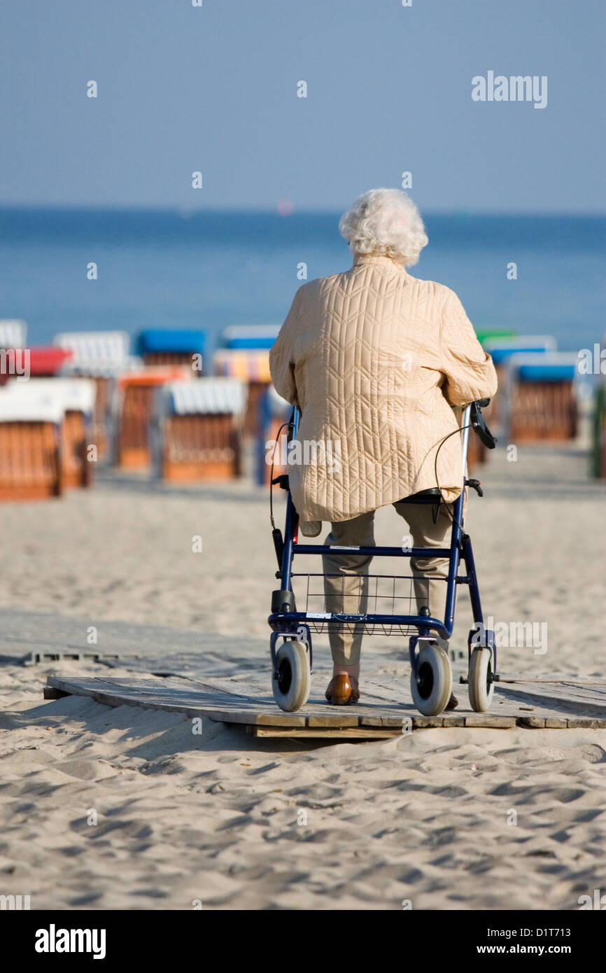 Rostock, Allemagne, vieille femme avec une marchette assis sur la plage Banque D'Images