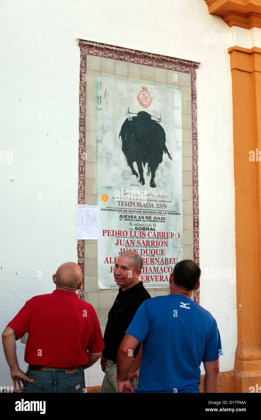 Séville, Espagne, les hommes regarder une affiche avec l'autre Stierkampfankuendigung Banque D'Images