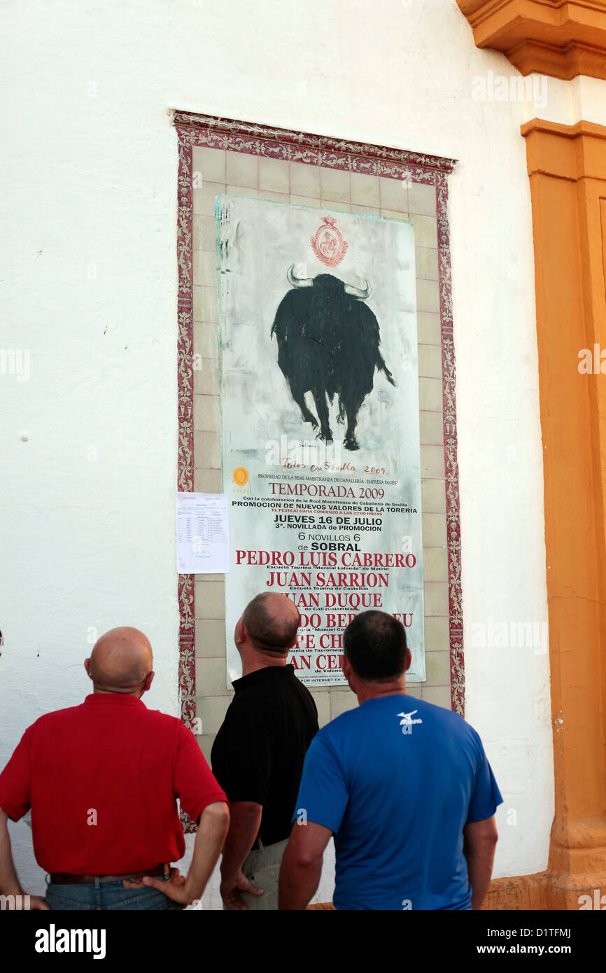 Séville, Espagne, les hommes regarder une affiche avec l'autre Stierkampfankuendigung Banque D'Images