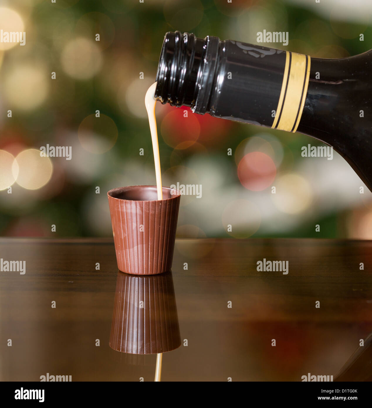 Irish Cream Liqueur laiteuse est versé dans le verre shot de chocolat avec arbre de Noël Banque D'Images