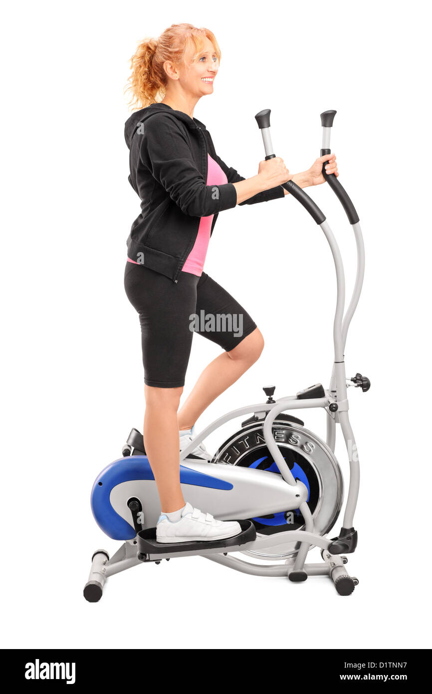 Full Length portrait of a young woman exercising on un cross trainer isolé sur fond blanc Banque D'Images