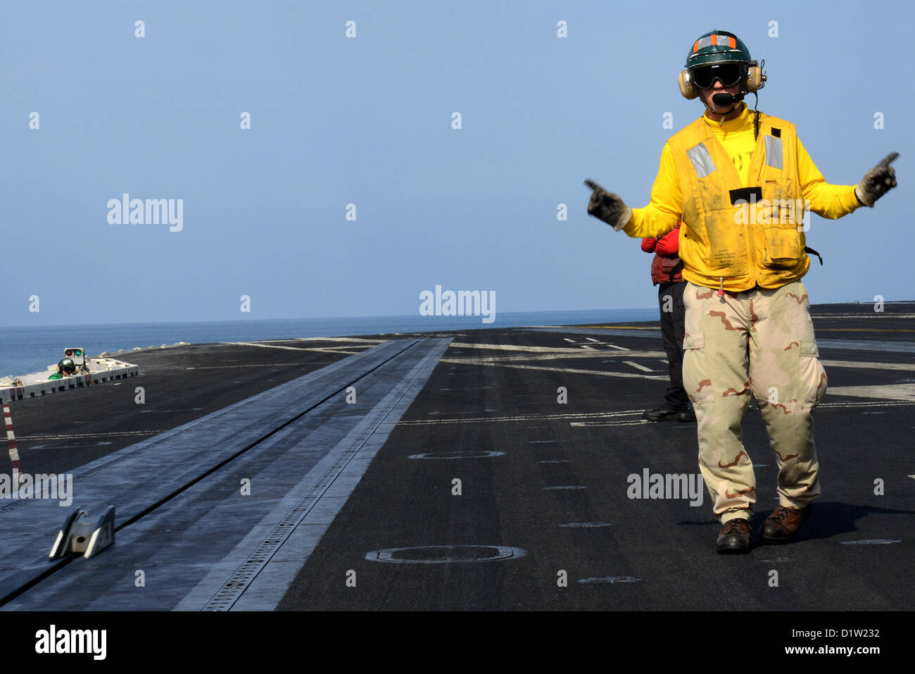 Un 'shooter' (catapulte/arrêt) Agent de signaux pour le lancement d'un avion sur le pont d'envol du porte-avions USS JOHN C. STENNIS (CVN 74). John C. Stennis est déployé sur le 5e Flotte des États-Unis zone de responsabilité des opérations de sécurité maritime, les efforts de coopération en matière de sécurité dans le théâtre et missions d'appui pour l'opération Enduring Freedom. JAN 6, 2013 (U.S. Photo de la marine) Banque D'Images