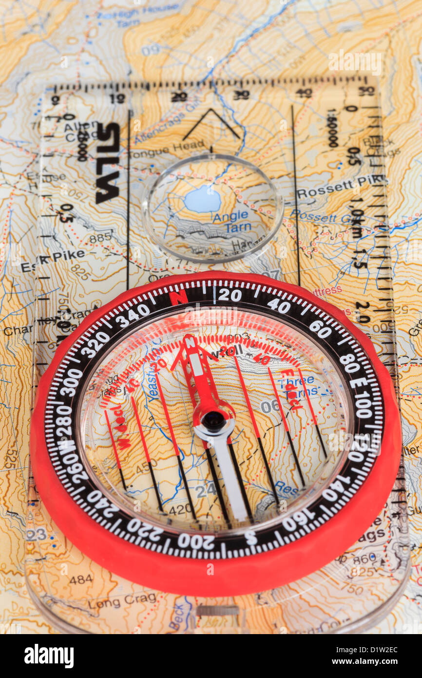Boussole d'orientation l'aiguille dirigée vers le nord avec les lignes de la grille sur un Harvey's 1:40000 Carte de randonnée et de la plaque du flèche pointant dans le sens de marche. UK Banque D'Images