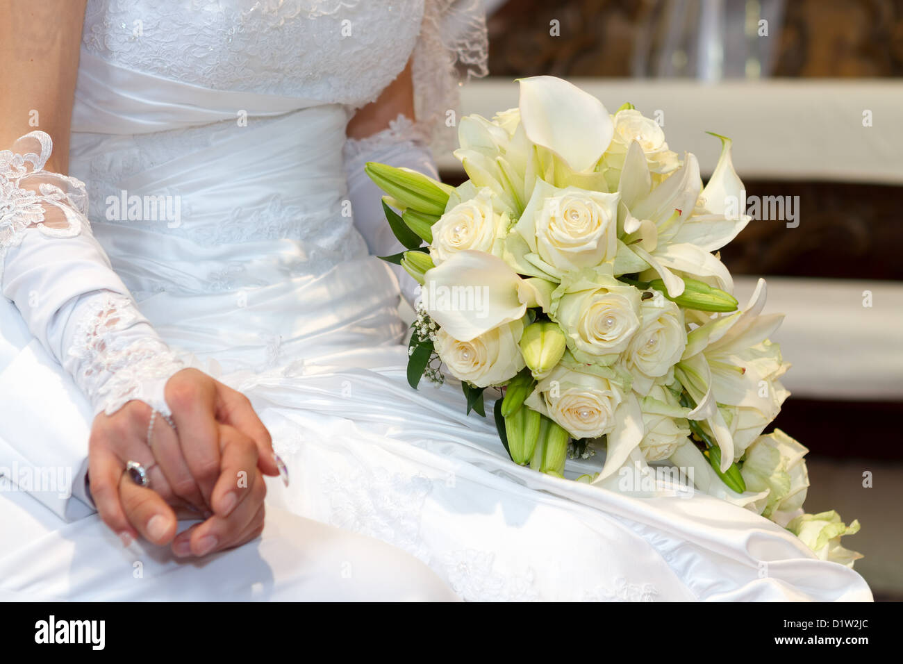 Jour de mariage mariée et se toilette mains avec bouquet de mariage Banque D'Images
