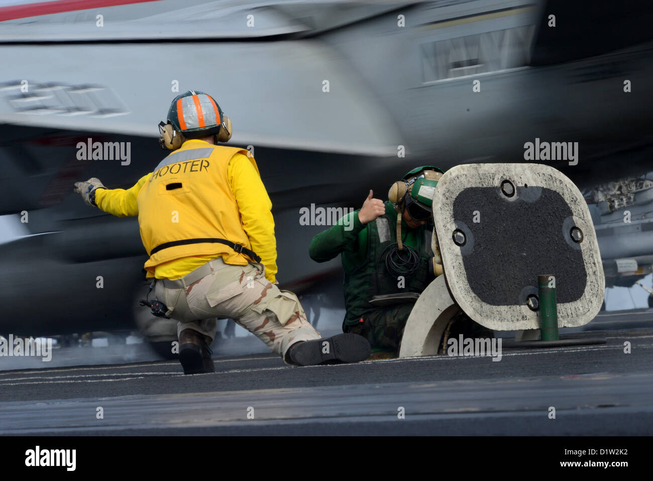 Un 'shooter' (catapulte/arrêt) Agent de signaux pour le lancement d'un avion sur le pont d'envol du porte-avions USS JOHN C. STENNIS (CVN 74). John C. Stennis est déployé sur le 5e Flotte des États-Unis zone de responsabilité des opérations de sécurité maritime, les efforts de coopération en matière de sécurité dans le théâtre et missions d'appui pour l'opération Enduring Freedom. JAN 6, 2013 (U.S. Photo de la marine) Banque D'Images