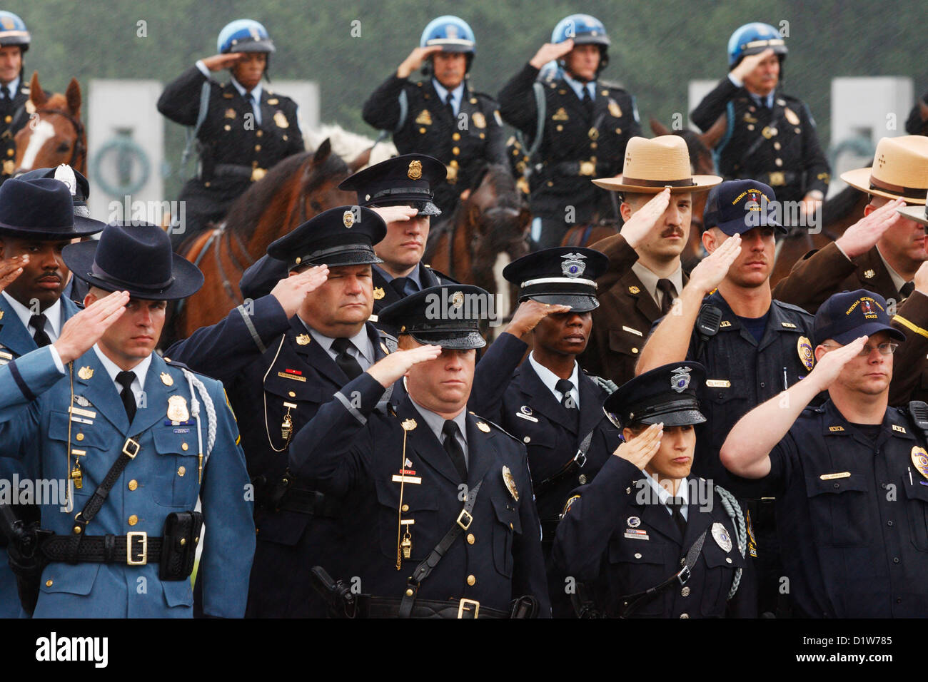 WASHINGTON, DC - 11 JUIN : les forces de l'ordre saluent sous une légère pluie alors que le corbillard portant le corps de l'ancien président des États-Unis Ronald Reagan passe devant le Mémorial de la seconde Guerre mondiale le 11 juin 2004 à Washington, DC. (Photographie de Jonathan Paul Larsen / Diadem images) Banque D'Images