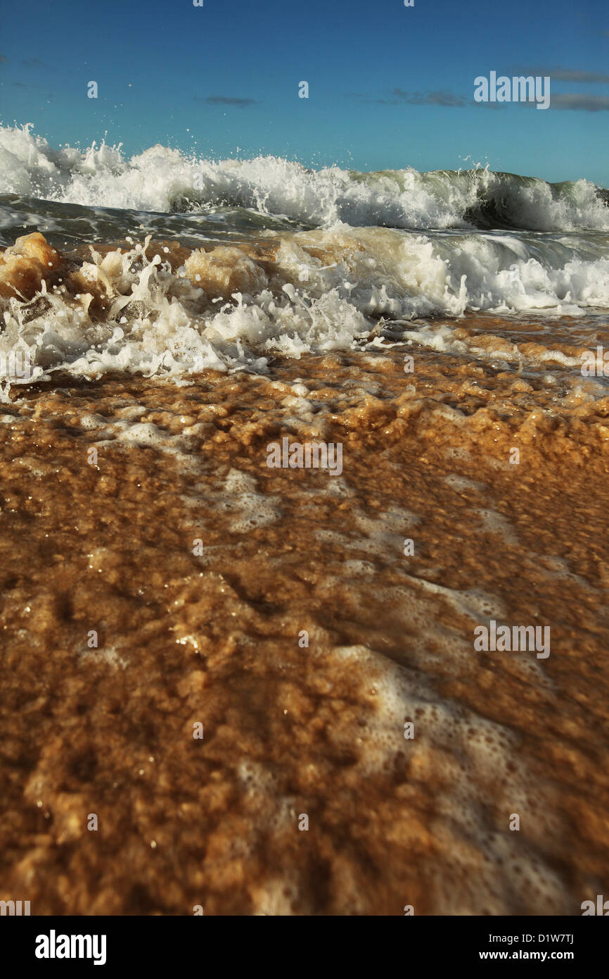 Close up de petites vagues se brisant sur le rivage. Banque D'Images
