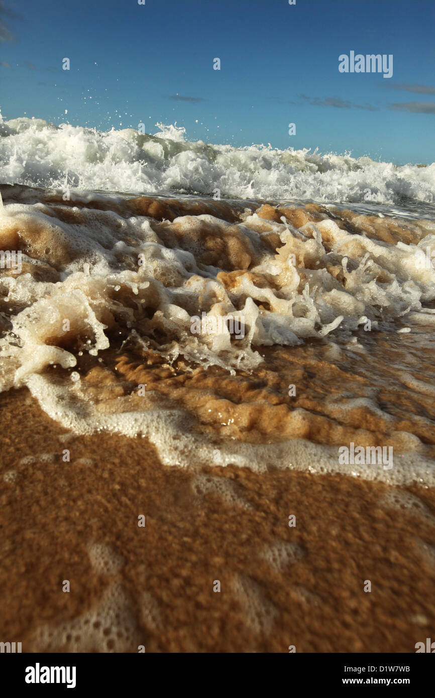 Close up de petites vagues se brisant sur le rivage. Banque D'Images