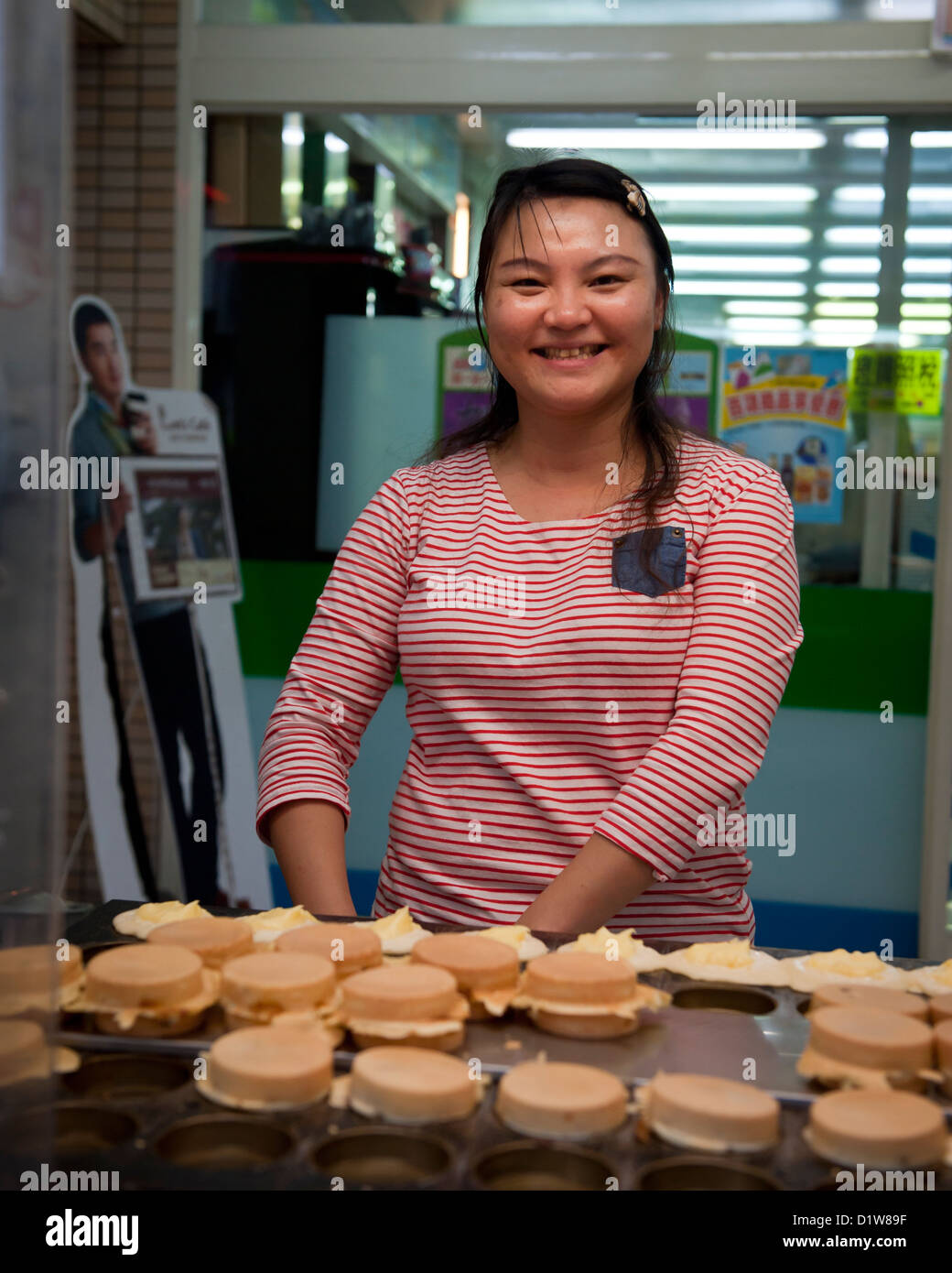 Vente de gâteaux Smiling girl un étal de Hwalien, Banque D'Images