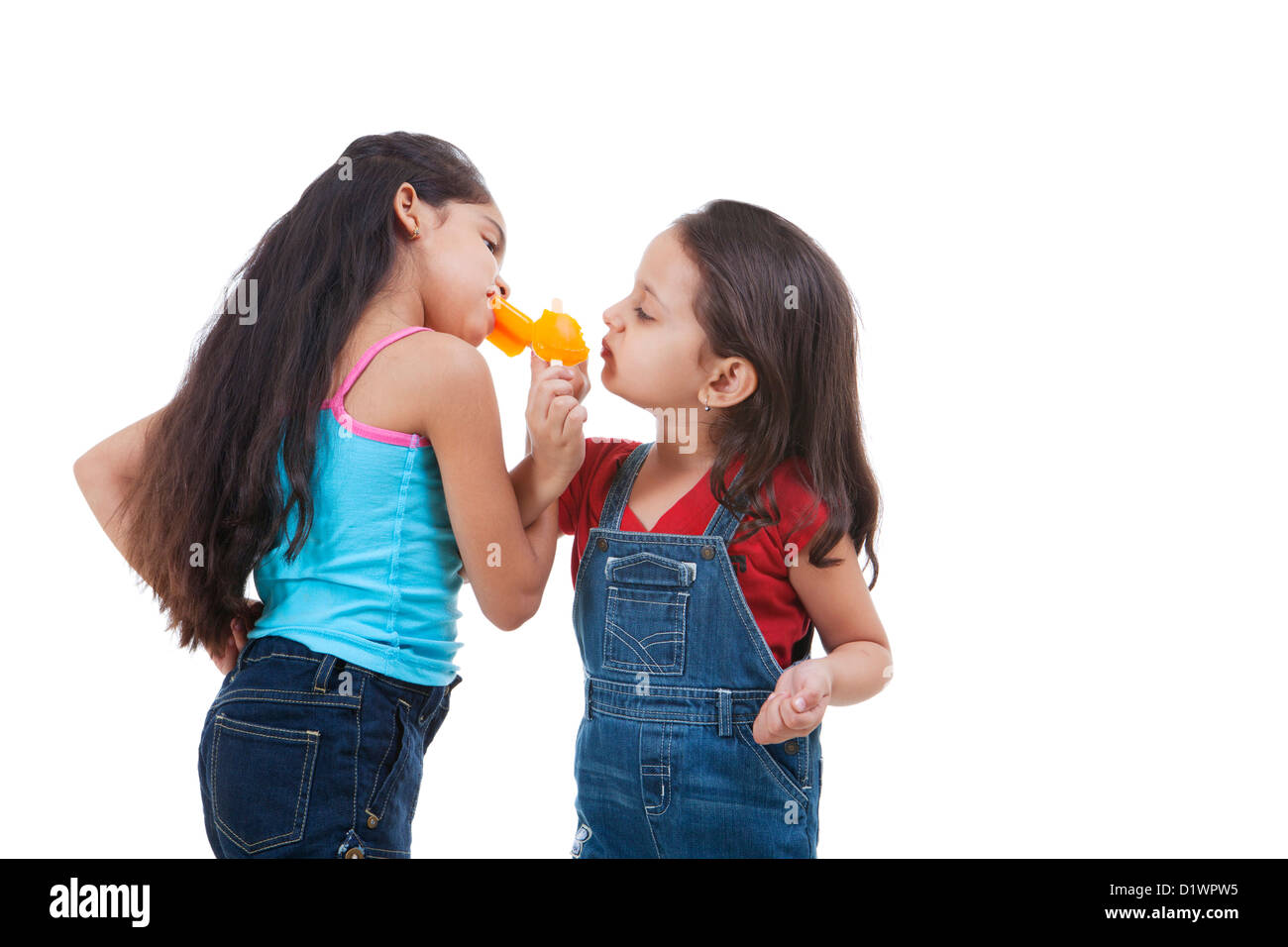 Girls eating ice lolly sur fond blanc Banque D'Images