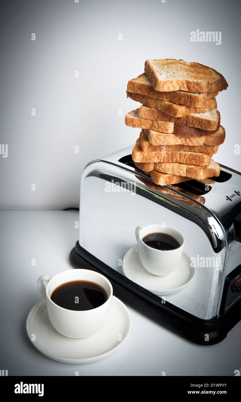 Monticule de toasts en équilibre sur le haut de grille-pain avec tasse de  café à côté de lui pour le petit déjeuner Photo Stock - Alamy