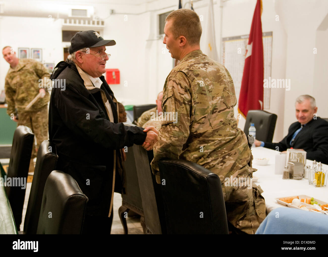 L'AÉRODROME DE BAGRAM (Afghanistan) - Le sénateur américain Carl Levin, un sénateur de l'état du Michigan, serre la main d'un soldat américain attaché à la Force opérationnelle combinée-1, 1re Division d'infanterie, au cours d'un déjeuner constitutifs de Bagram Airfield, l'Afghanistan, le 7 janvier 2013. Levin et des États-Unis Le sénateur Jack Reed, hauts sénateur de Rhode Island, a visité les troupes de leurs Etats respectifs, pour rehausser le moral et d'examiner les efforts déployés par les États-Unis en Afghanistan. (U.S. Photo de l'armée par le Sgt. Christopher Bonebrake, Mobile 115e Détachement des affaires publiques) Banque D'Images