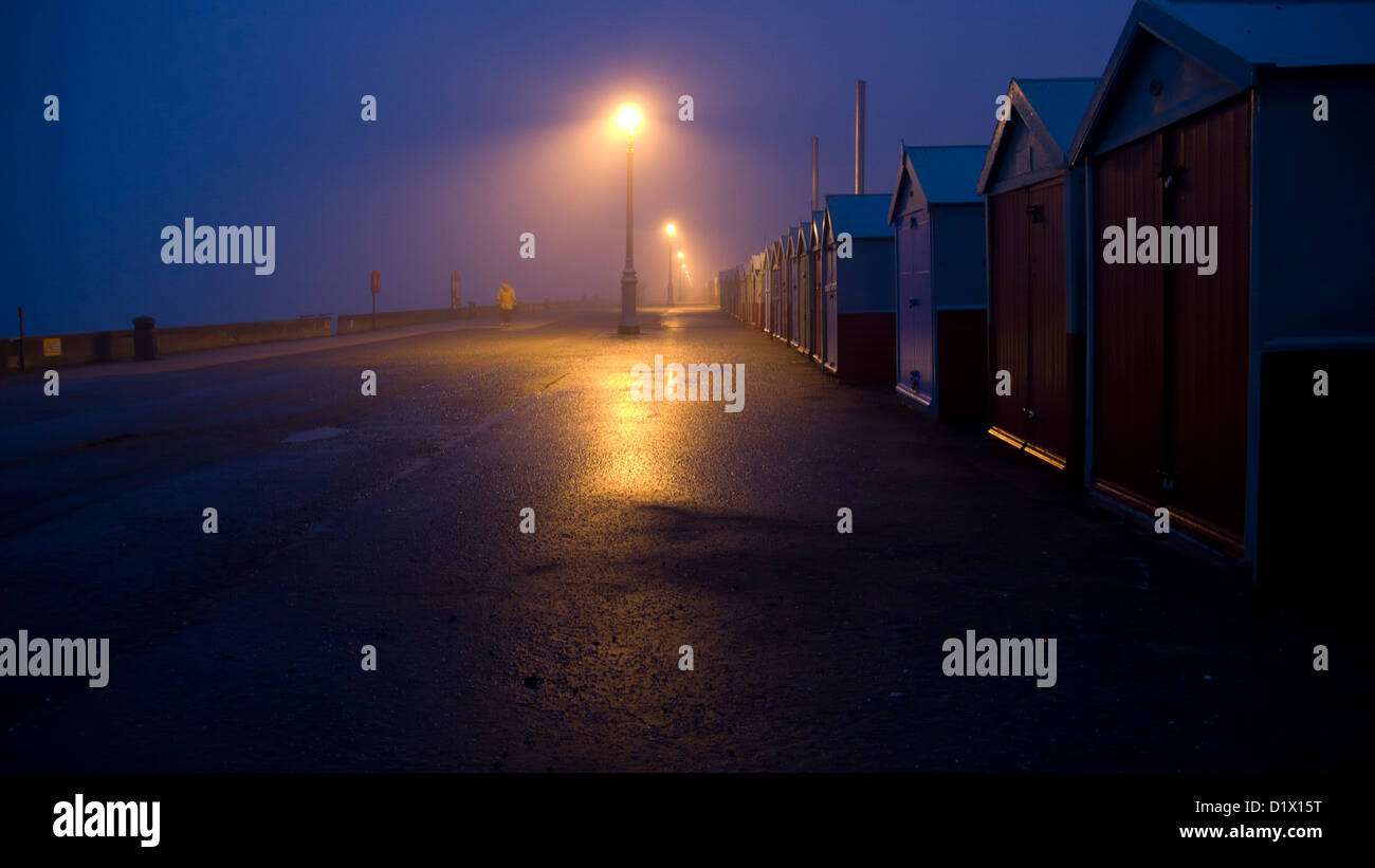 Cabines de plage, la nuit, des lampadaires, Brighton et Hove,figure, rue humide lointain Banque D'Images