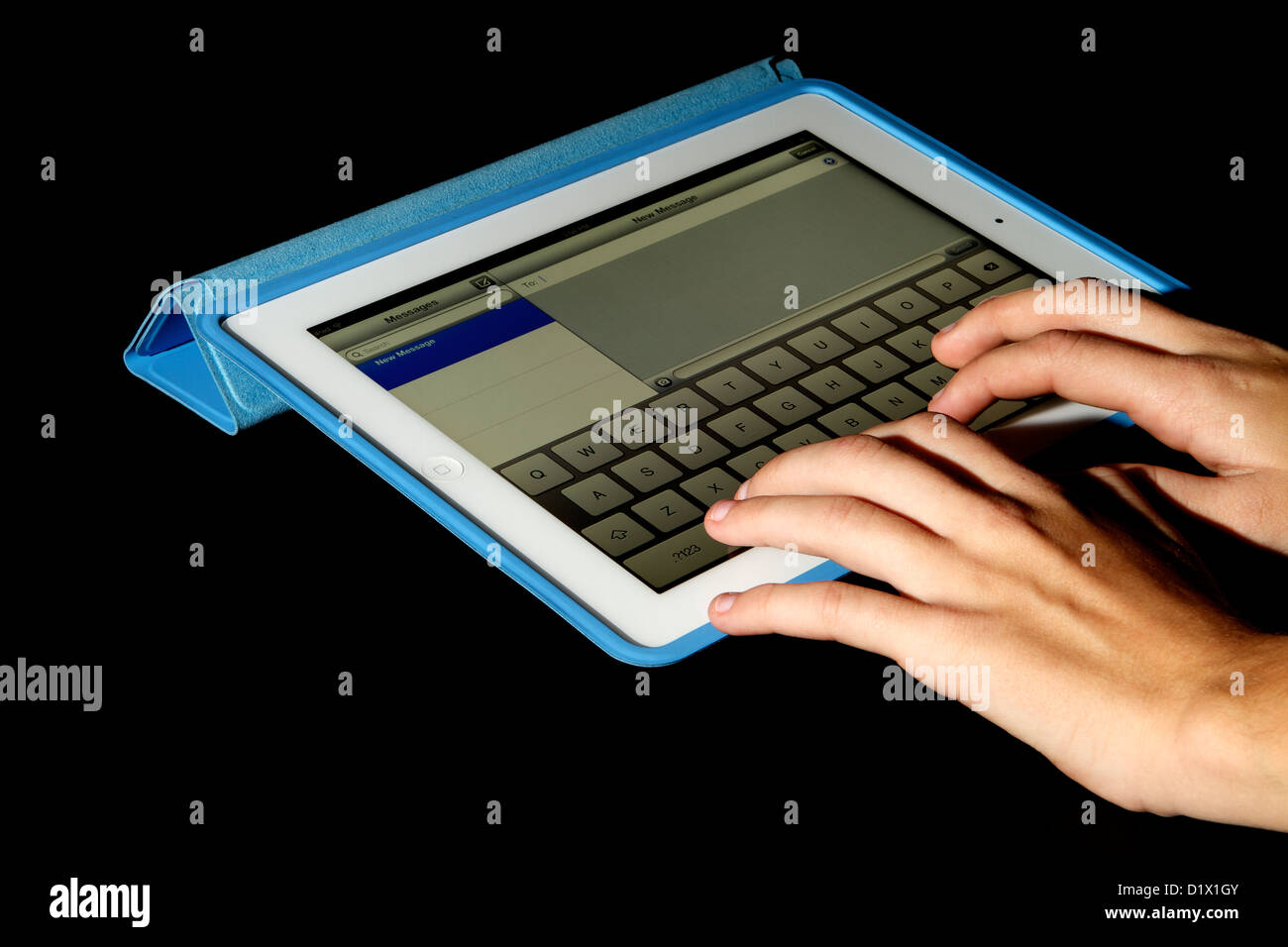 Un iPad avec écran Retina blanc dans un étui bleu sur un fond noir avec une jeune femme en train de rédiger un message Banque D'Images