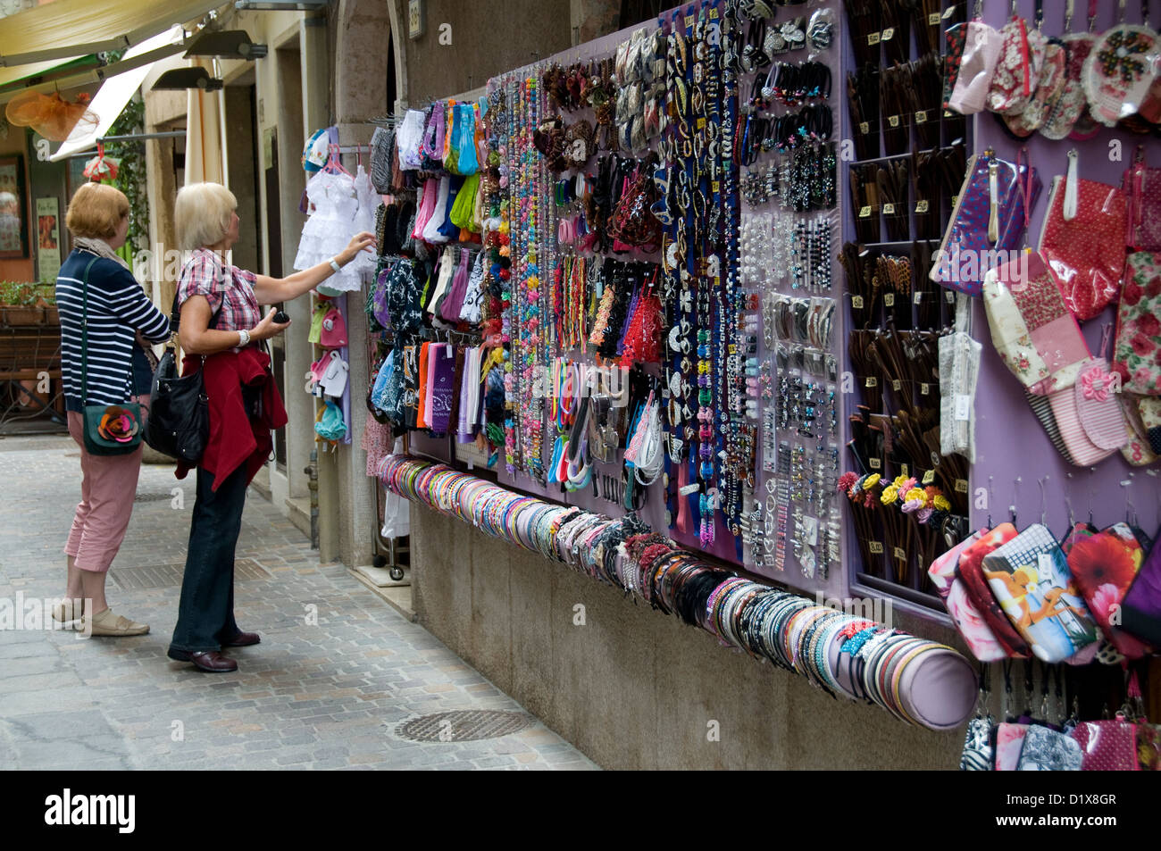 Un couple de touristes qui admirent des vêtements italiens pour enfants dans une boutique de la ville de Garda nommée d'après le lac de Garde. La petite ville se trouve sur un Banque D'Images