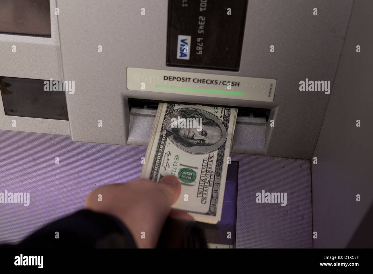 Homme déposer de l'argent sur un distributeur de billets Banque D'Images
