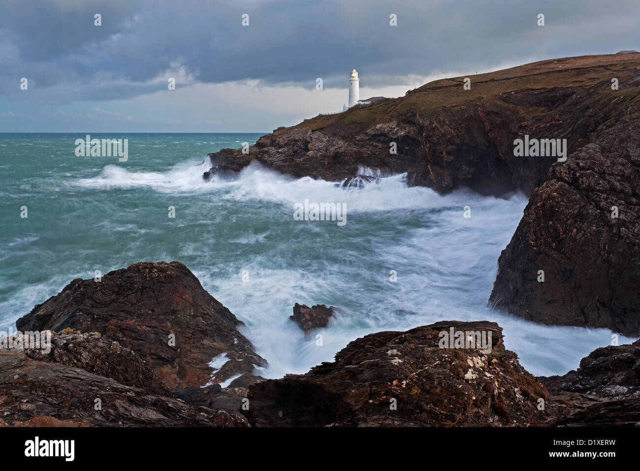 Trevose Head Lighthouse à Cornwall avec des vagues se briser sur les rochers qui forment cette partie de l'emblématique Cornish coastlin robuste Banque D'Images