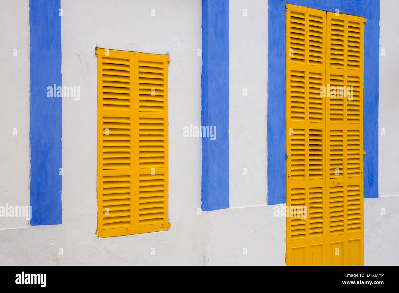 Portocolom, Majorque, Iles Baléares, Espagne. Façade de maison bleu et blanc avec volets jaunes dans la vieille ville. Banque D'Images