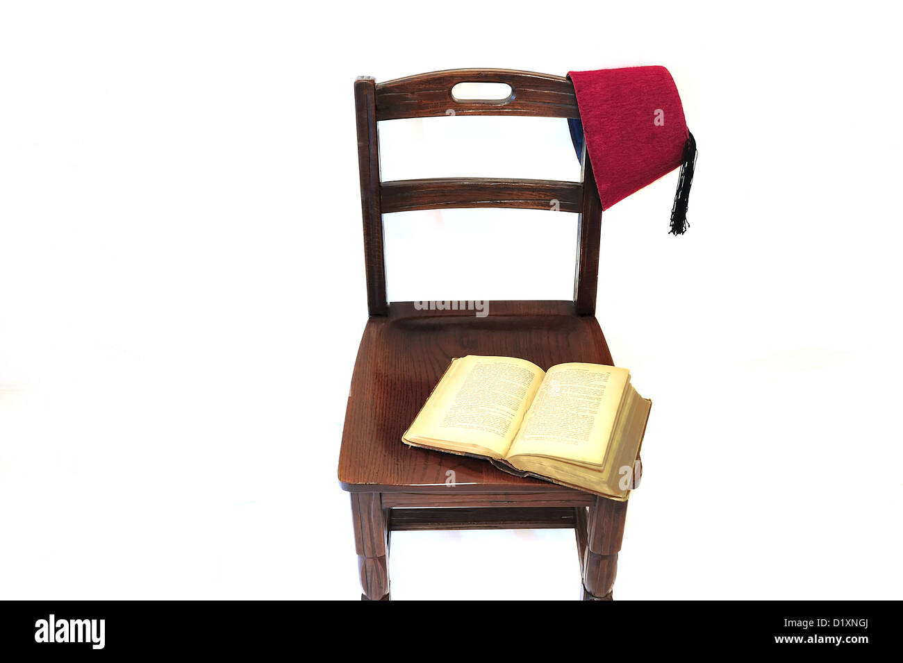 Un vieux livre ouvert laissé ouvert sur une vieille chaise. Un historique du Moyen-Orient (tarboosh) est suspendu à la présidence Banque D'Images