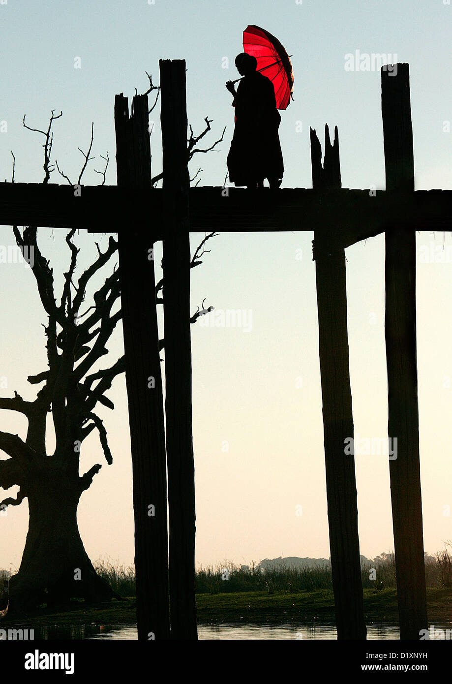 Le moine bouddhiste traversant le pont U Bein au coucher du soleil, Amarapura, près de Mandalay, Birmanie, du Myanmar, de l'Asie du sud-est. Banque D'Images