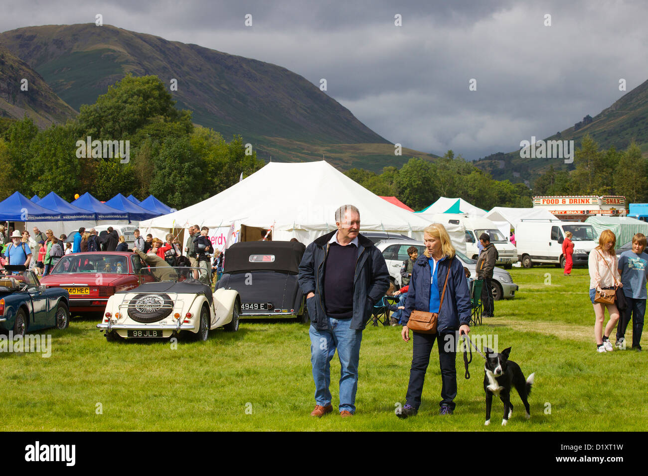L'homme et la femme à leur chien à Grasmere Lakeland Sports,Parc National de Lake District, Cumbria, Angleterre. Royaume-uni, Banque D'Images