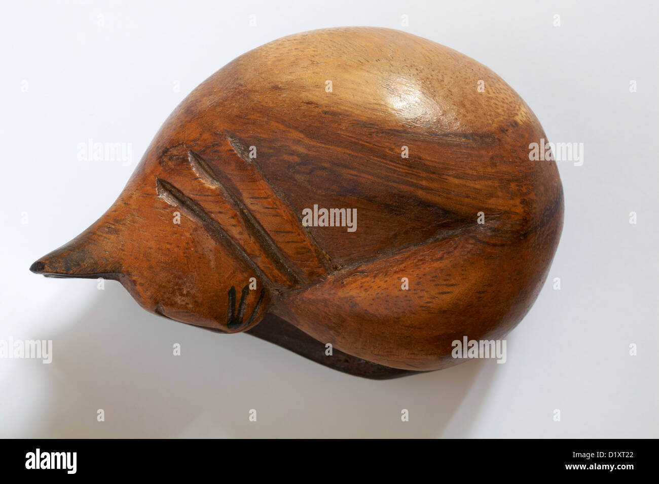 Recroquevillée sleeping cat sculpture en bois isolé sur fond blanc Banque D'Images