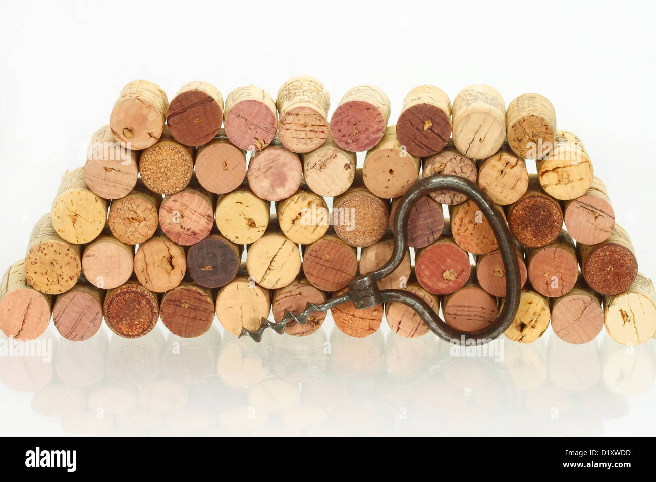 Tire-bouchon Vintage contre de la pile de wine corks avec réflexion sur la table en verre Banque D'Images