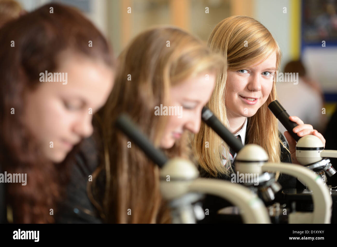 Les filles de l'école en utilisant des microscopes au cours d'une leçon de science à Pates Grammar School à Cheltenham, Gloucestershire UK Banque D'Images